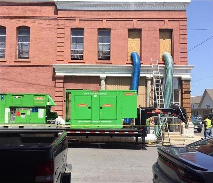 brick building, green machine outside