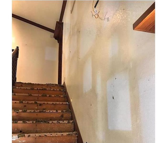 staircase with smoke damage on the walls